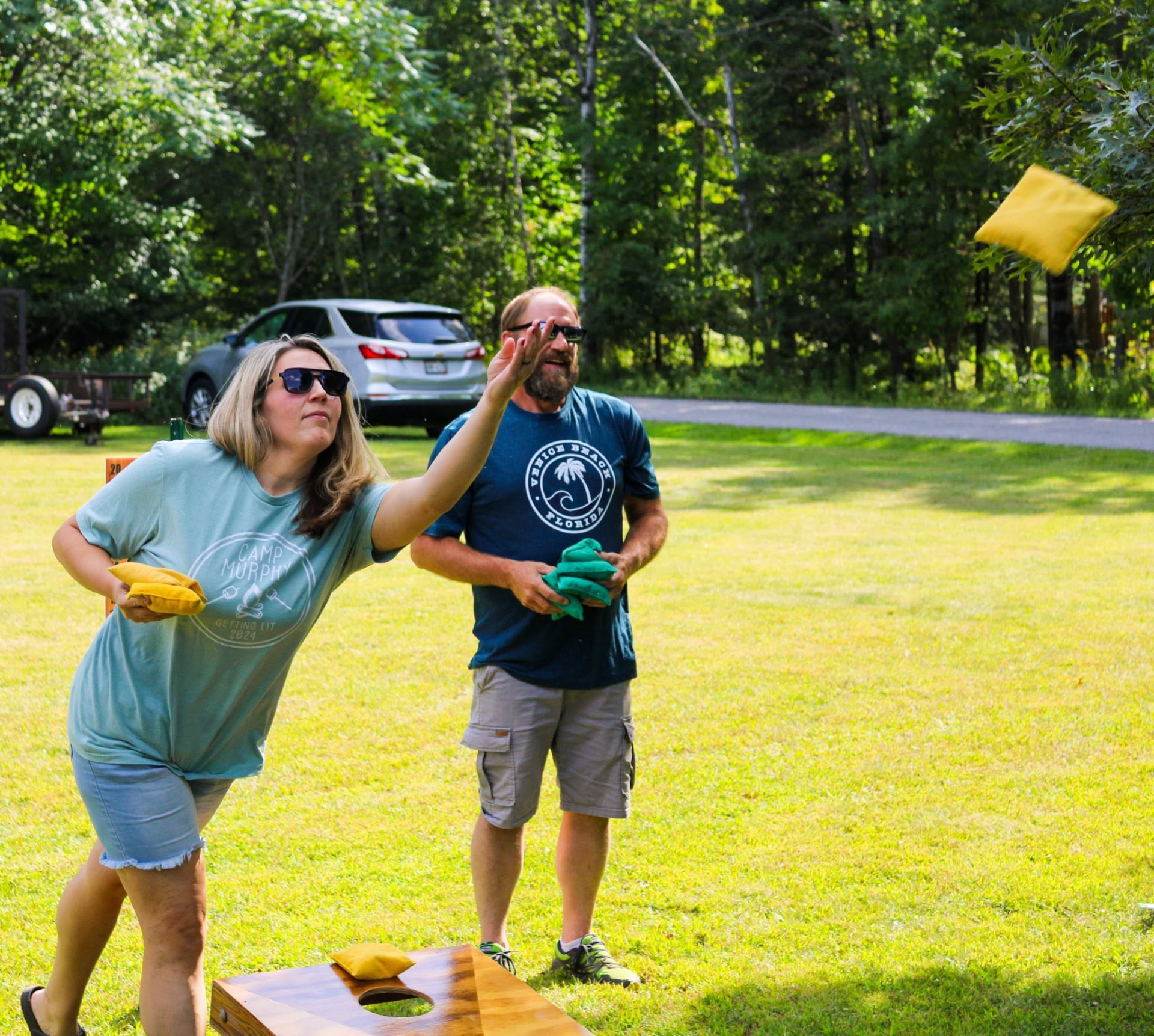 Campers playing cornhole on the lawn at Heaven’s Up North Campground