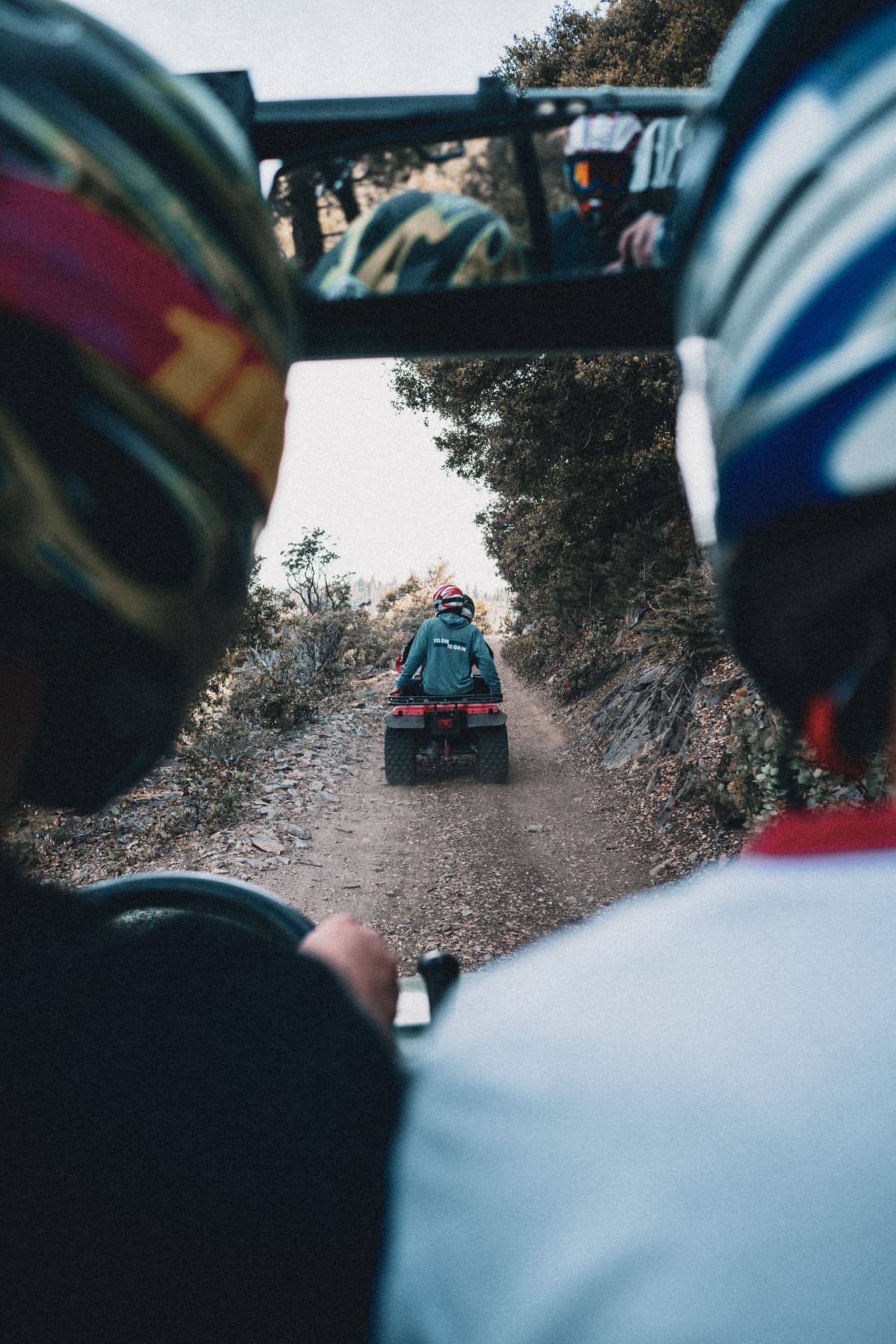 Rider's view from a UTV following an ATV down a trail